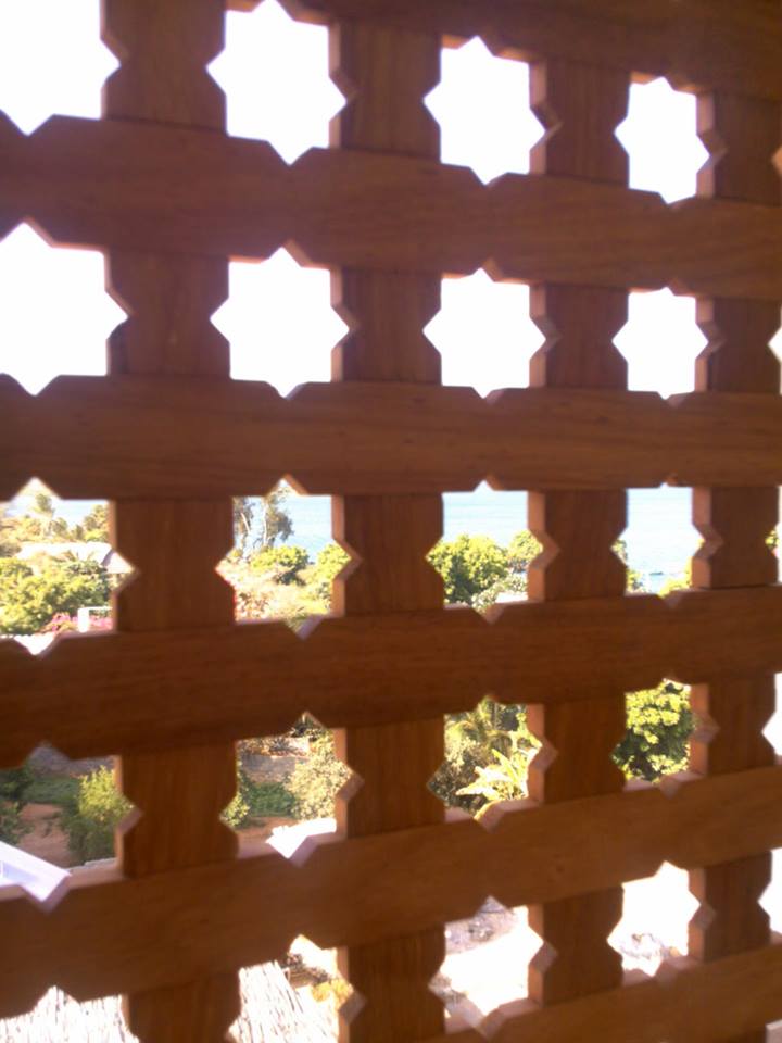 Traditional carved timber lattice screen with a sea view